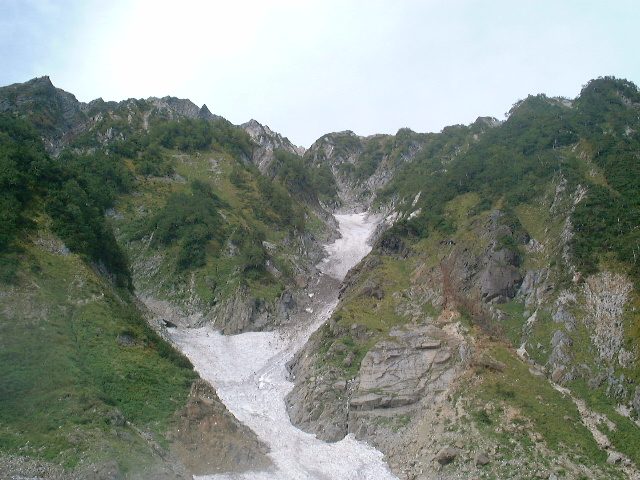 険しい山の隙間に雪渓はある