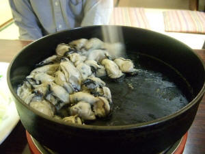 鉄鍋で牡蠣を炒める