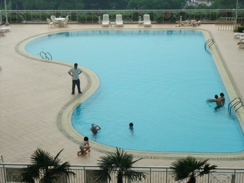 サービスアパートのプールで泳ぐ人達