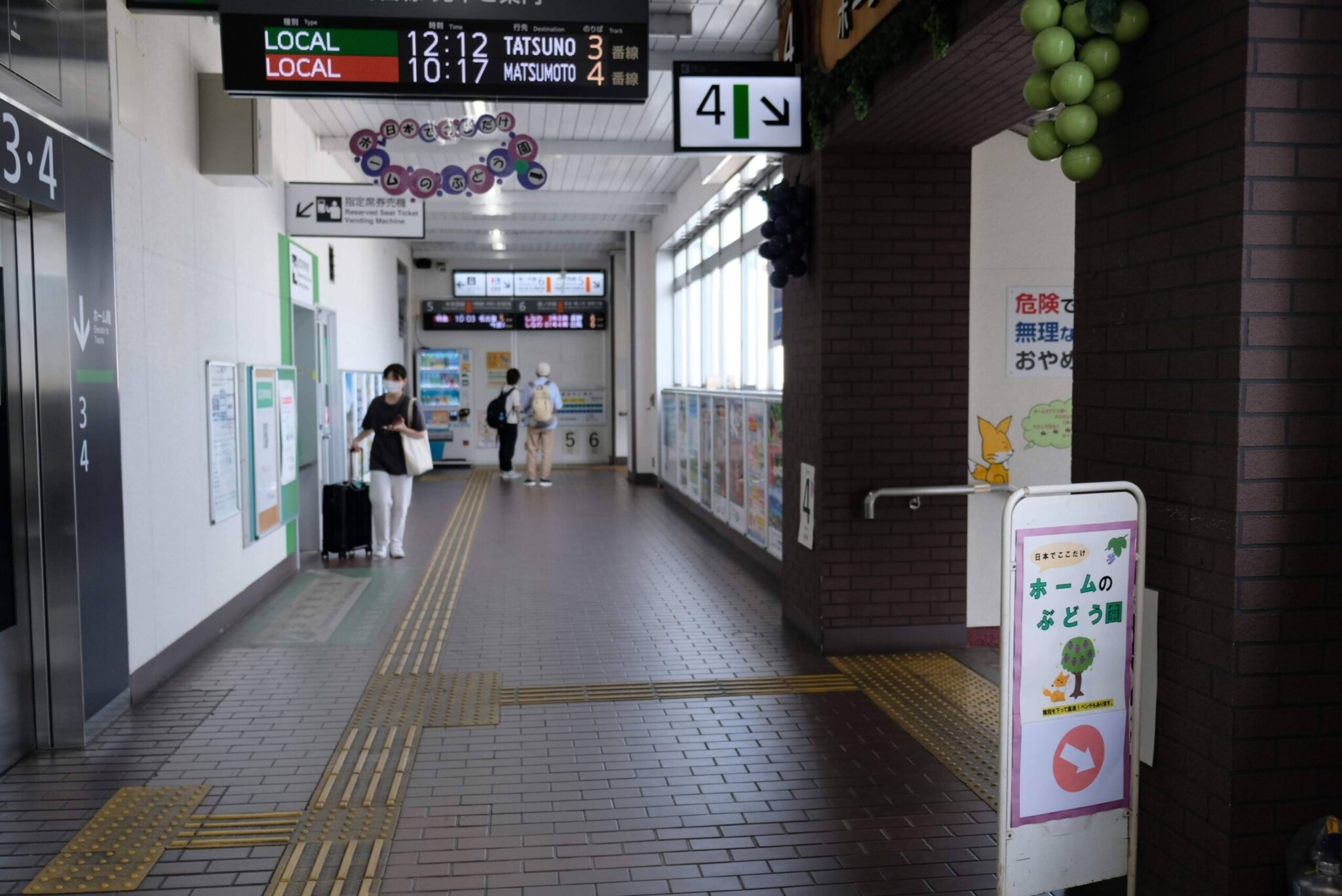 駅通路に掲げられた「ホームのぶどう園」の看板。塩尻駅を象徴するユニークな導線案内。