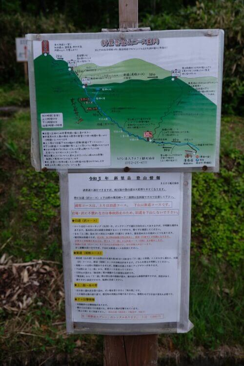 斜里岳登山コースの案内板。旧道(沢)と新道(尾根)のルート詳細と、クマ目撃情報、登山時の注意喚起が詳しく記載されている。