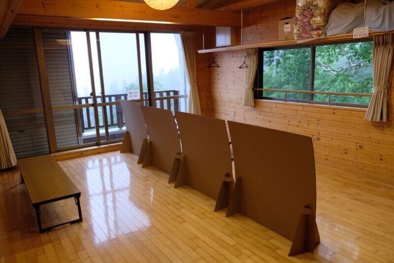 貸出中止の寝具が積まれた棚と、段ボールで区切られた部屋の様子。