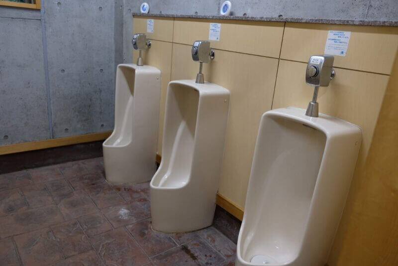 清潔に保たれた男性用小便器. 洗浄水に再利用水を使用している旨の注意書き。