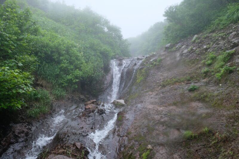段差から水が落ち、小滝のようになっている登山道の様子