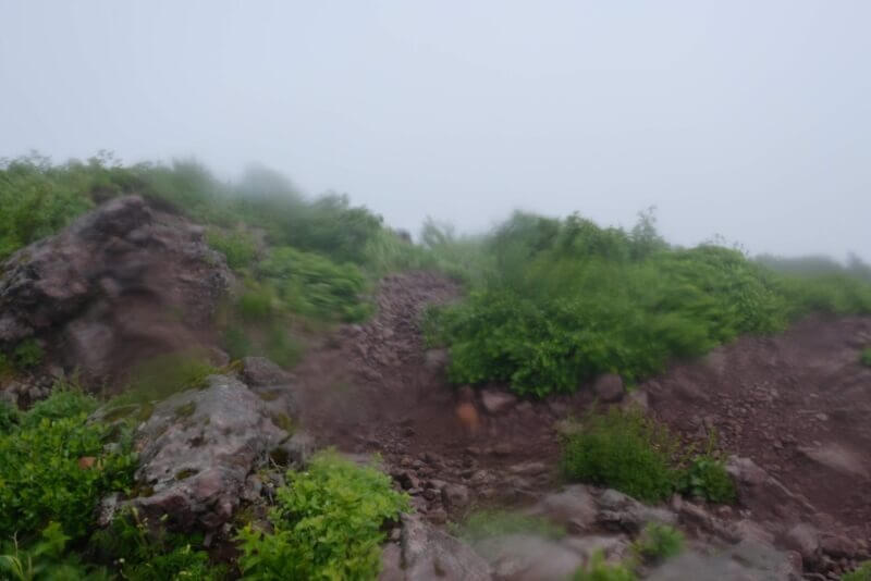霧の中の急峻な岩場と登山道