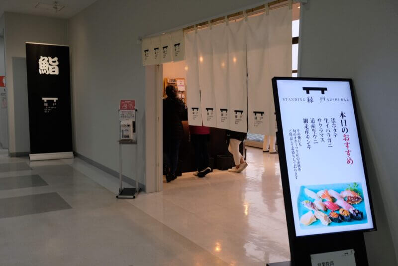 女満別空港の立ち食い寿し 縁戸（えんど）の店舗外観と本日のおすすめ看板