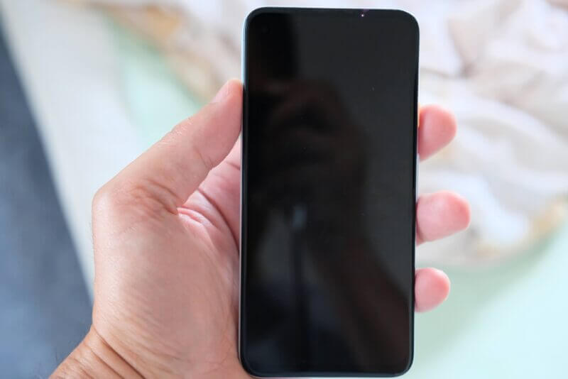 左手で持ったスマートフォンの背面。一見すると何の変哲もない日常のひとコマ。