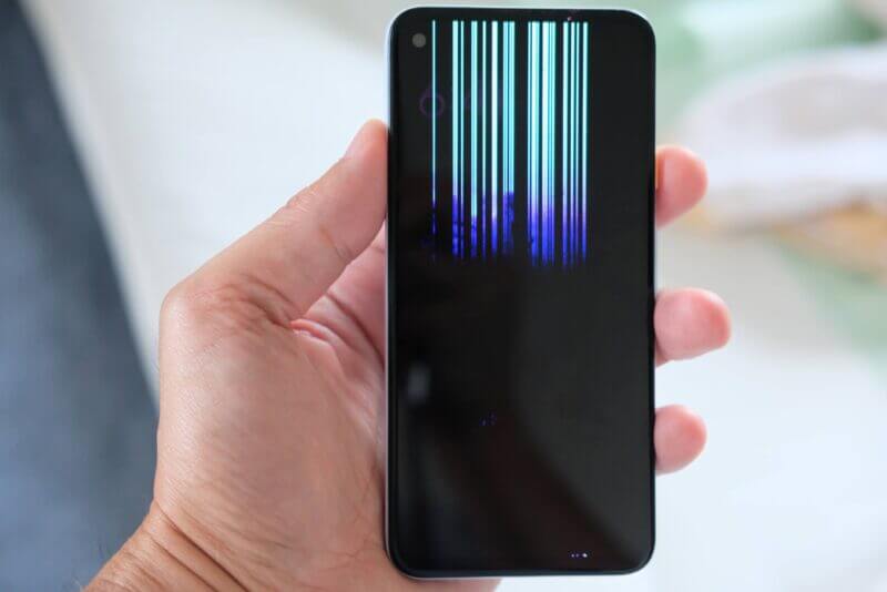 液晶が破損し、垂直に多数のカラーノイズラインが入ったスマートフォンの画面。
