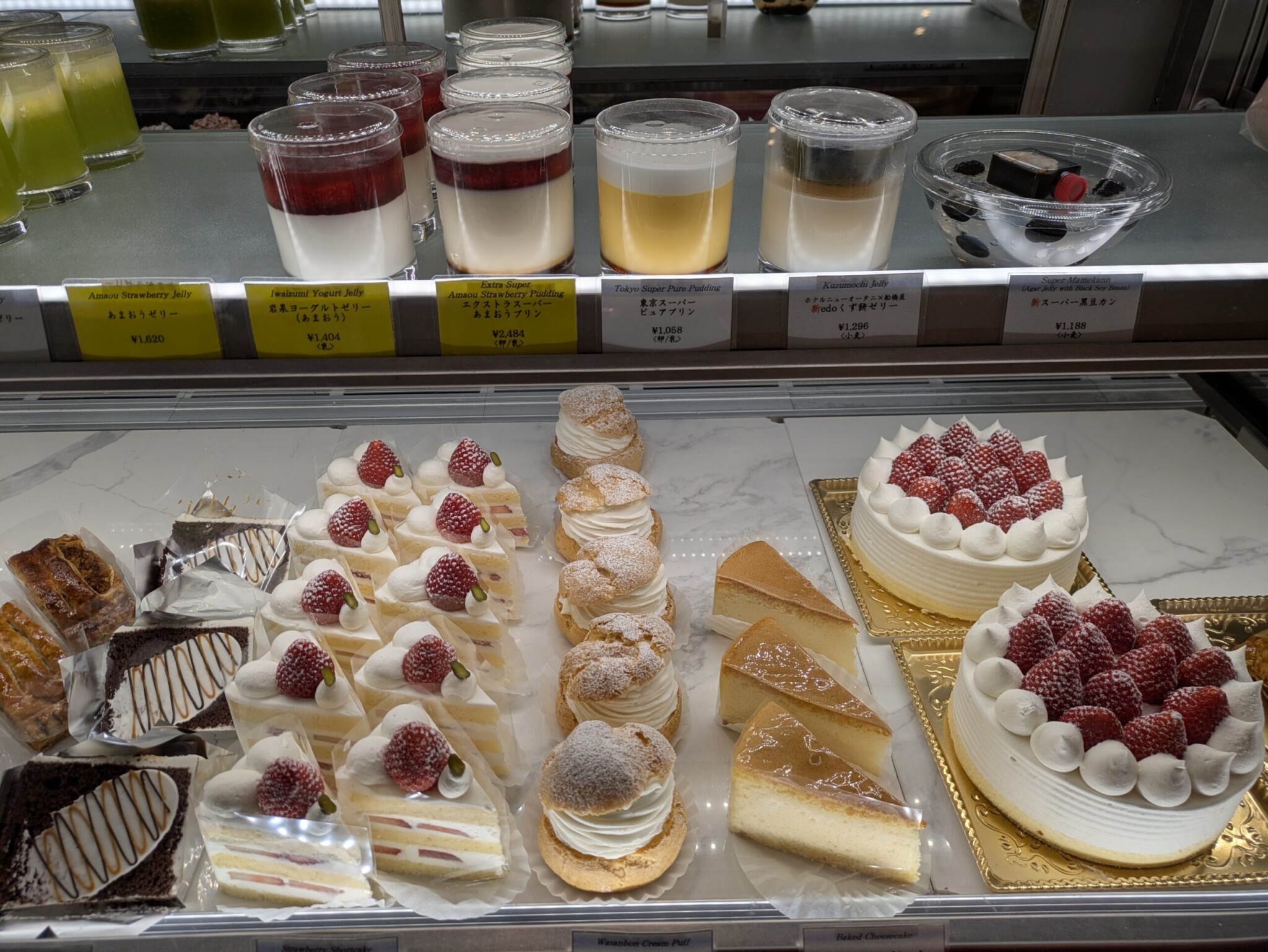 ショーケースに並ぶ色とりどりのプリンやショートケーキ。